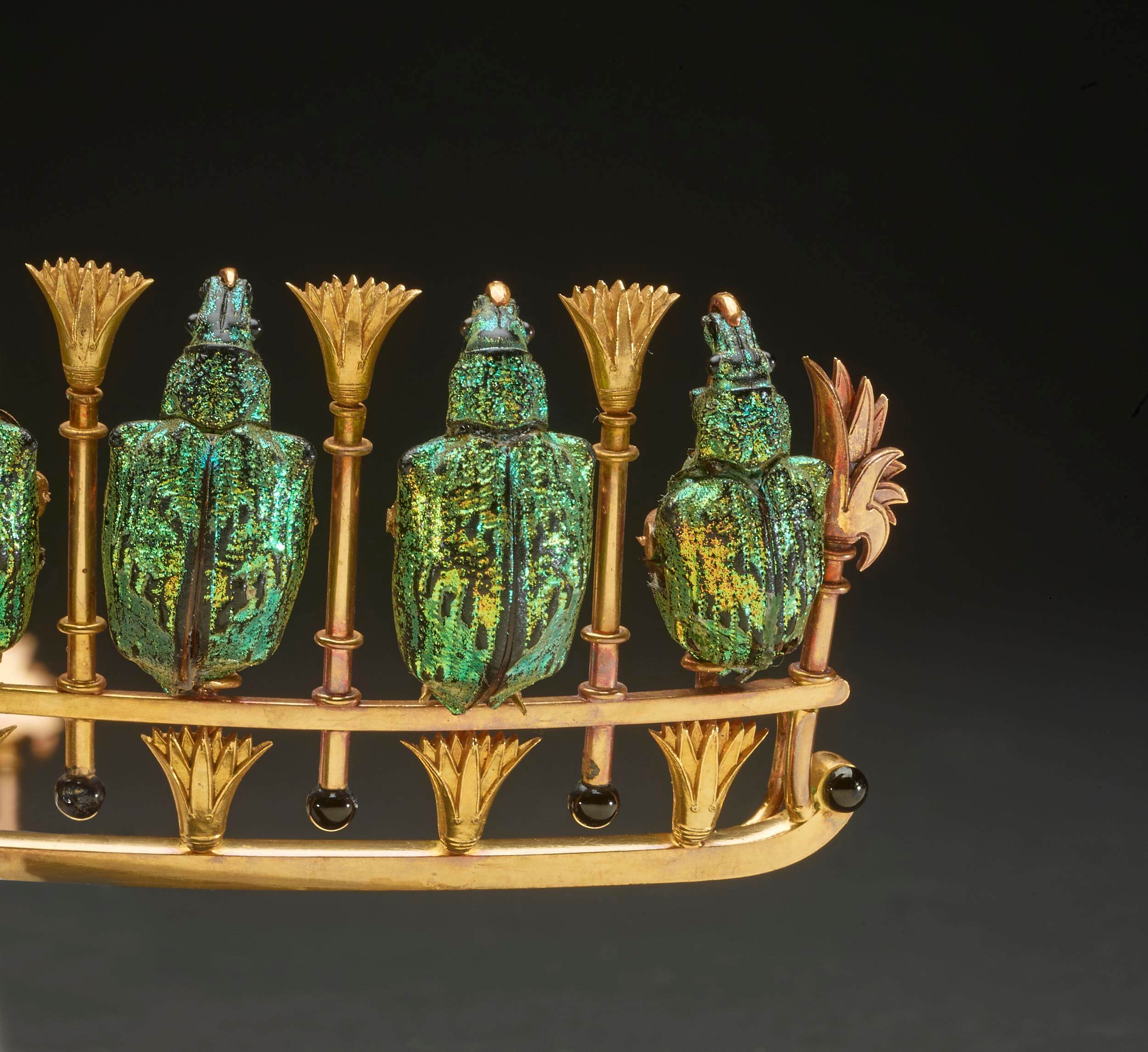 close up view of a portion of the tiara, showing the weevil shells interspersed with the lotus motifs