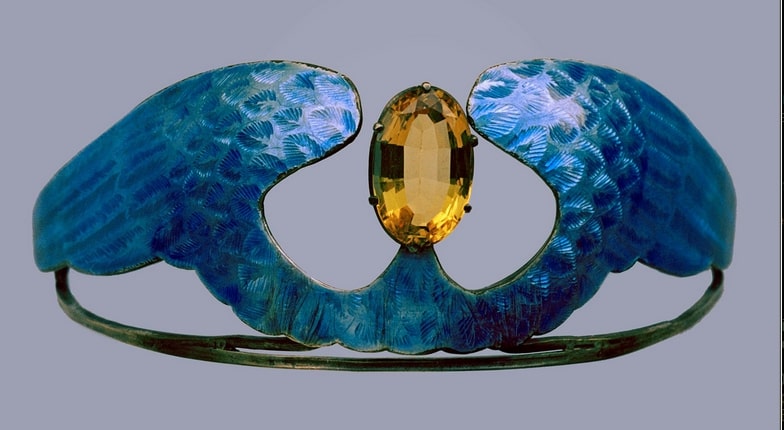 Silver tiara with a large oval citrine and blue enamel wings.