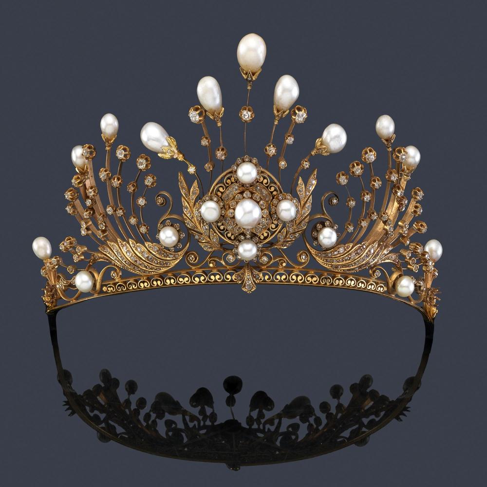 18K gold tiara set with old and rose cut diamonds, pearls and button pearls. It presents a central body in the form of a rose window with a central pearl and four smaller pearls, with a double border of diamonds and decoration in the form of ears of wheat enriched with rose-cut diamonds. At both ends it presents motifs in the form of feathers with diamonds and pearls. With a pompadour in the form of fine turned strips, sprinkled with diamonds and a pearl finish with a 'tremblant' effect, giving the piece a beautiful movement.