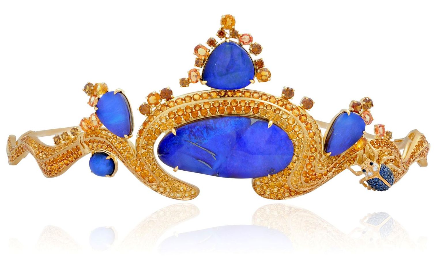 Gold tiara with a wavy shape at either end and meeting in an open oval in the middle. The central stone is a large blue Australian boulder opal and there are 2 smaller boulder opals on either side. The tiara is studded with topazolites, hessonites, yellow sapphires, blue sapphires, black sapphires and diamonds. There is a very small jeweled dung beetle on the right side.
