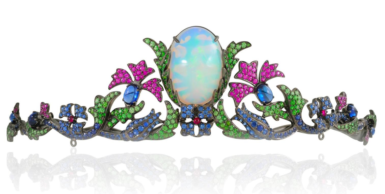 Black rhodium tiara set with large central Welo opal. There are branches of leaves and flowers set with sapphires, rubies, spinels and tsavorite garnets.