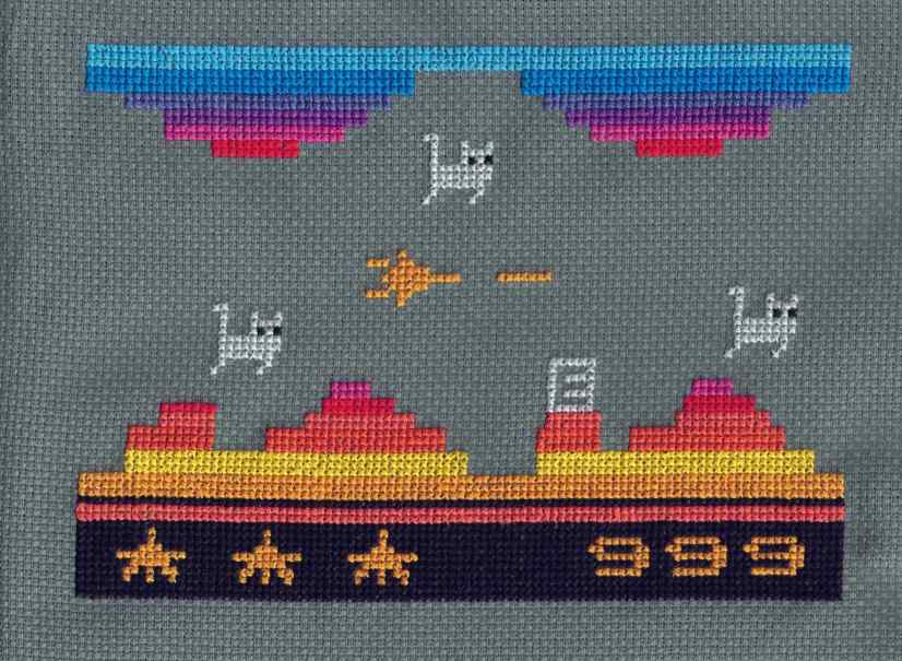 Cross stitch done on dark gray Aida cloth and is a rendition of the Atari 2600 version of Vanguard but with flying gray cats instead of spaceships. At the top there are 3 rows of blue stitches extending the length of the cross-stitch. Underneath are 2 smaller stacks with gradually smaller rows. The colors are darker blue, indigo, violet, magenta and red. In the center of the image is a small yellow spaceship that has fired a shot (small line of yellow). There are 3 light gray cats flying from left to right, one above the spaceship and the others are on the left and right. Underneath the cats are gradually larger colorful rows, starting as 3 peaks but gradually becoming one at the bottom. The colors starting from the top are magenta, red, light orange, dark orange, bright yellow and orange. This last row is where they all meet and become one solid line. Under that is a single row of black, a double row of red-orange, and then 10 rows of black. In the middle of this last black row on the left are 3 orange star shapes and on the right are the numbers 999. On one of the peaks on the right side is a gray block with an E in the middle.