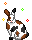 White bunny with brown and black splotches, and floating sparkles.