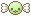 piece of round green candy with wrapper twists and a cute face
